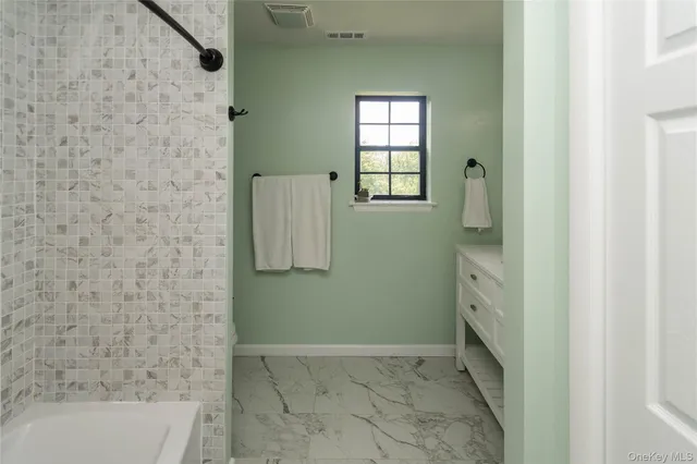 a bathroom with a bathtub and shower