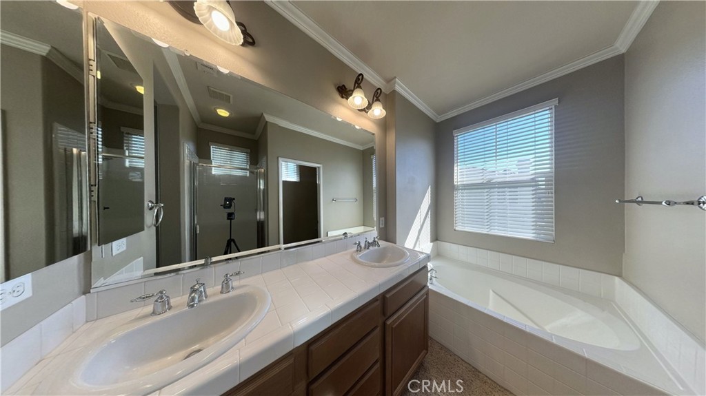 7701 Chambray Place, Unit 2 Rancho Cucamonga, CA 91739 - Photo 19 of 39 a bathroom with a bathtub a double vanity sink and mirror