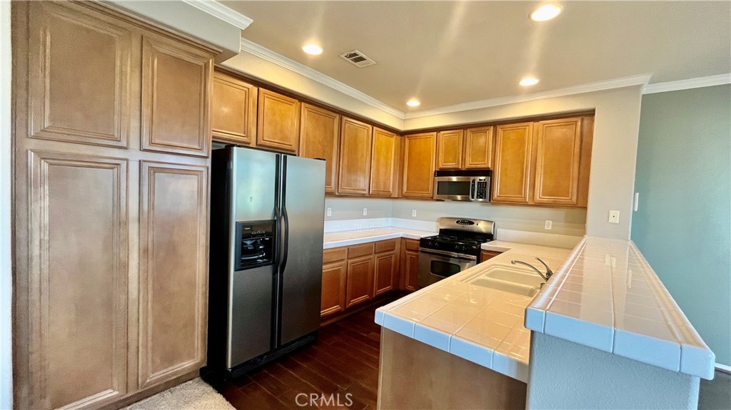 7701 Chambray Place, Unit 2 Rancho Cucamonga, CA 91739 - Photo 5 of 39 a kitchen with refrigerator cabinets and a counter top space