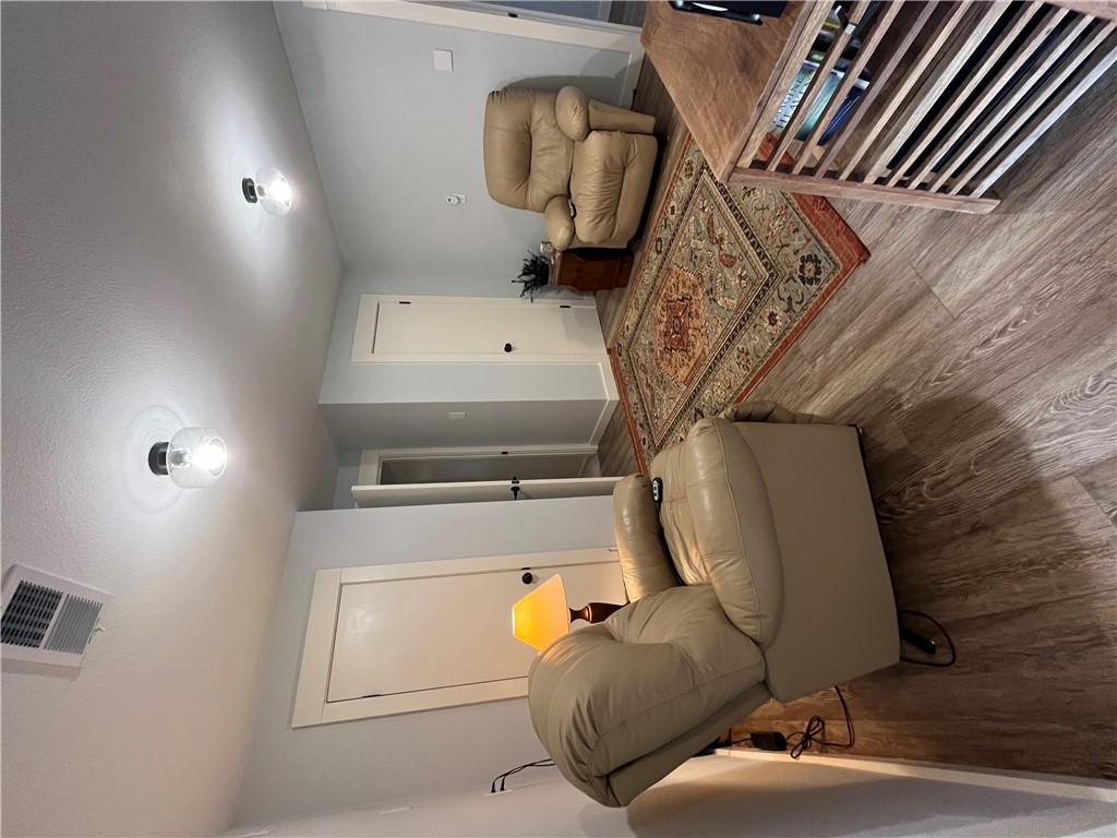 1102 North Travis Avenue Cameron, TX 76520 - Photo 28 of 48 Living area featuring light wood finished floors and a textured ceiling
