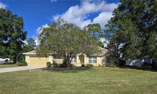 a front view of a house with a garden and tree