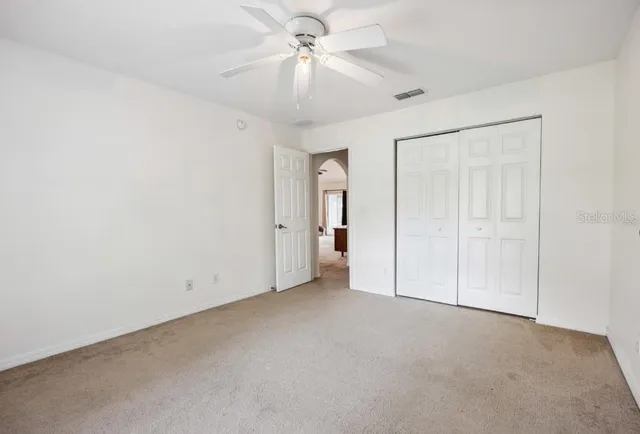 an empty room with a ceiling fan and a fan
