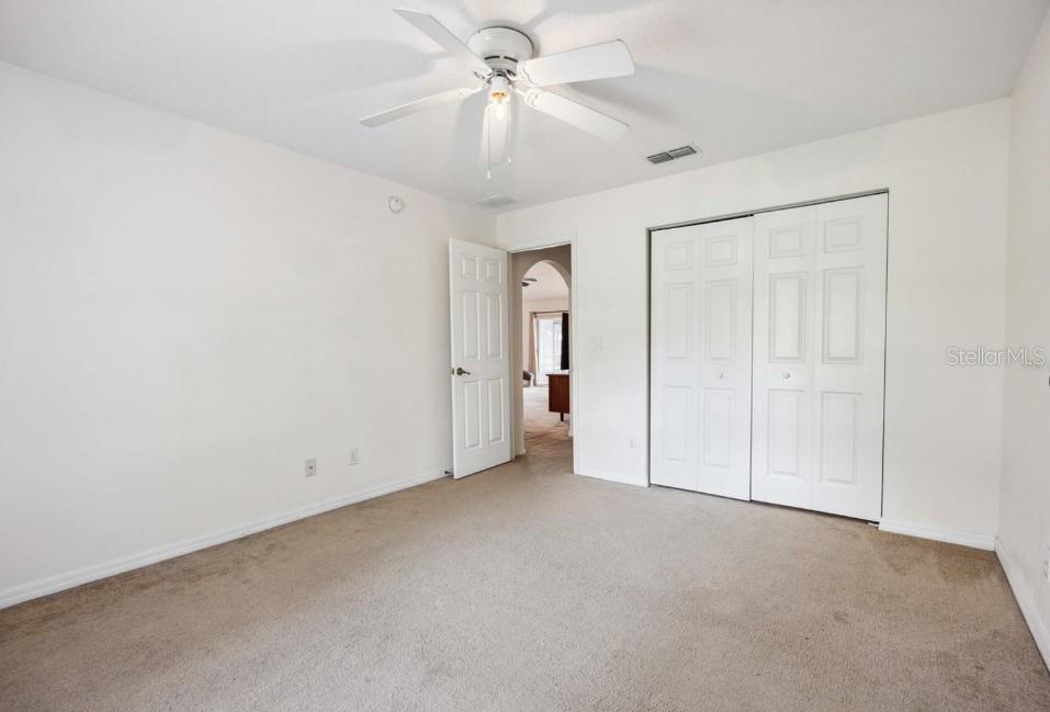 4300 Northwest 4th Circle Ocala, FL 34475 - Photo 18 of 34 an empty room with a ceiling fan and a fan