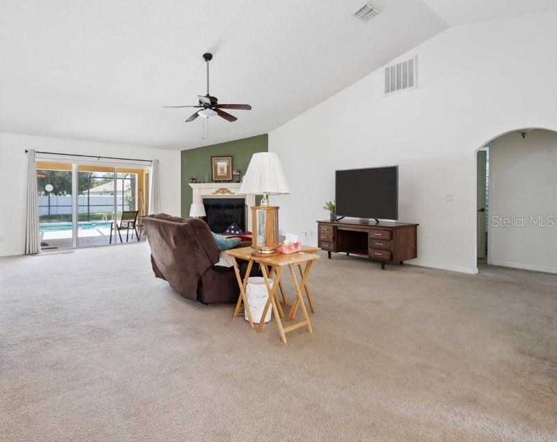 4300 Northwest 4th Circle Ocala, FL 34475 - Photo 6 of 34 a living room with furniture a fireplace and a flat screen tv