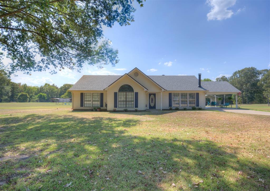 8835 Sebastian Road Keithville, LA 71047 - Photo 2 of 21 One-story residence with a covered carport, gabled rooflines, and a paved driveway