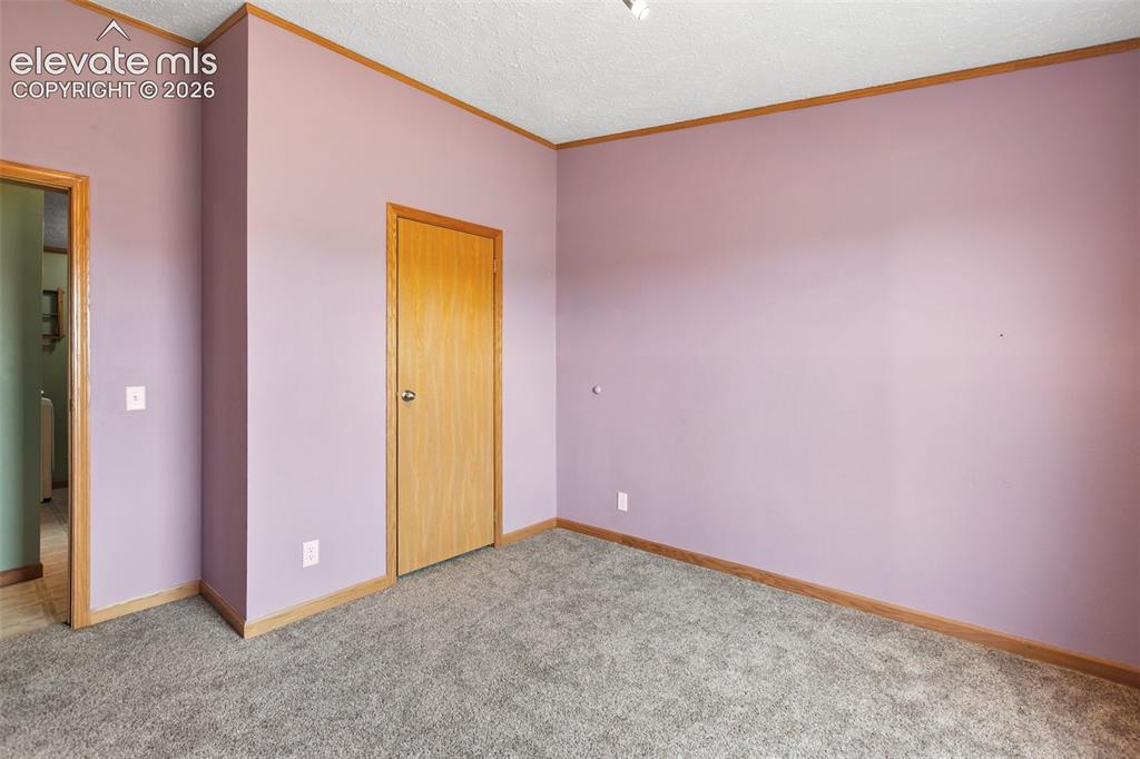 1350 South Calhan Highway Yoder, CO 80864 - Photo 38 of 45 Interior room featuring neutral wall color, wood-finish trim, and gray carpet flooring