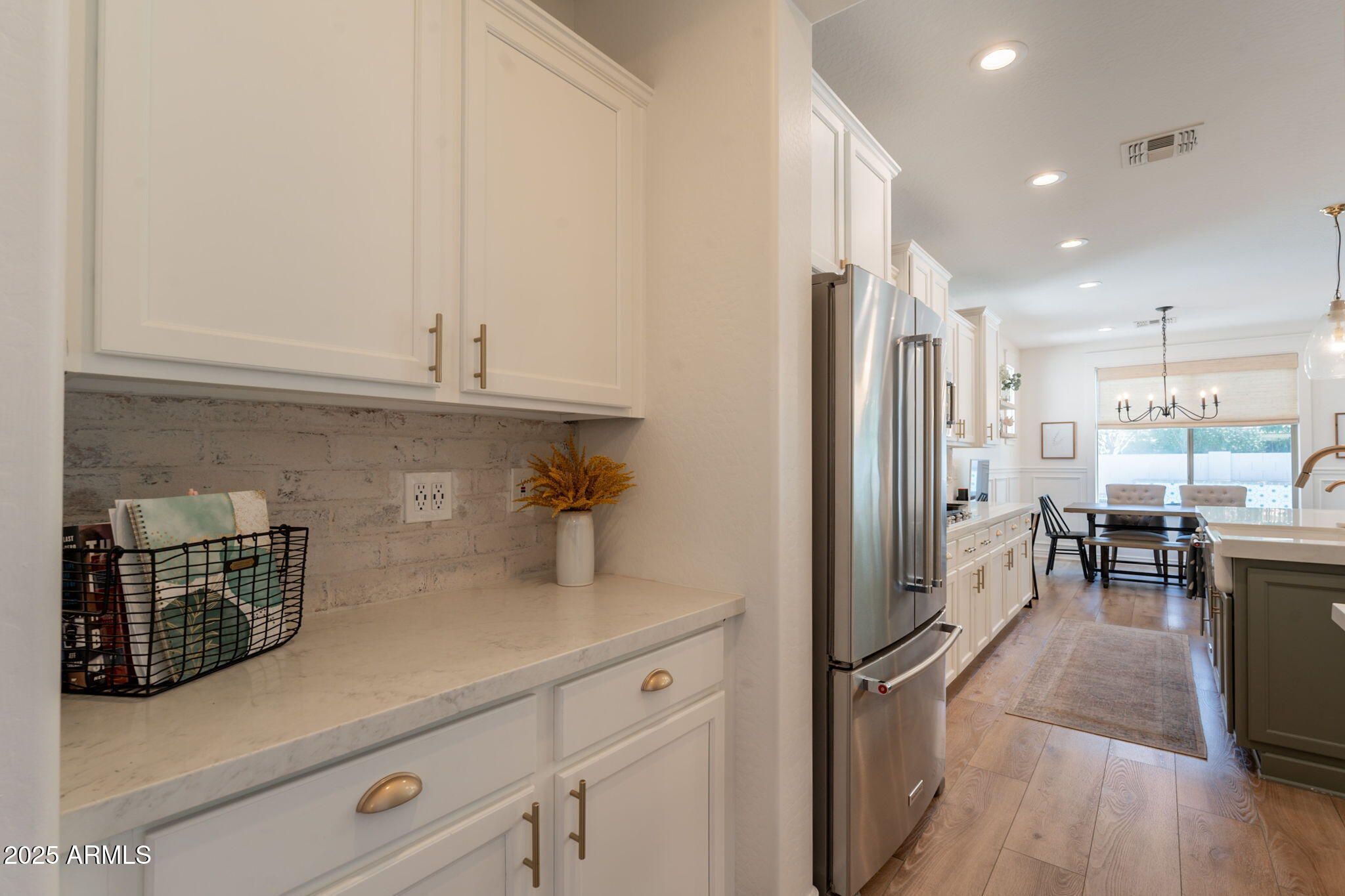 3931 East Weather Vane Road Gilbert, AZ 85296 - Photo 32 of 83 a kitchen with stainless steel appliances a refrigerator a stove a sink and white cabinets with wooden floor