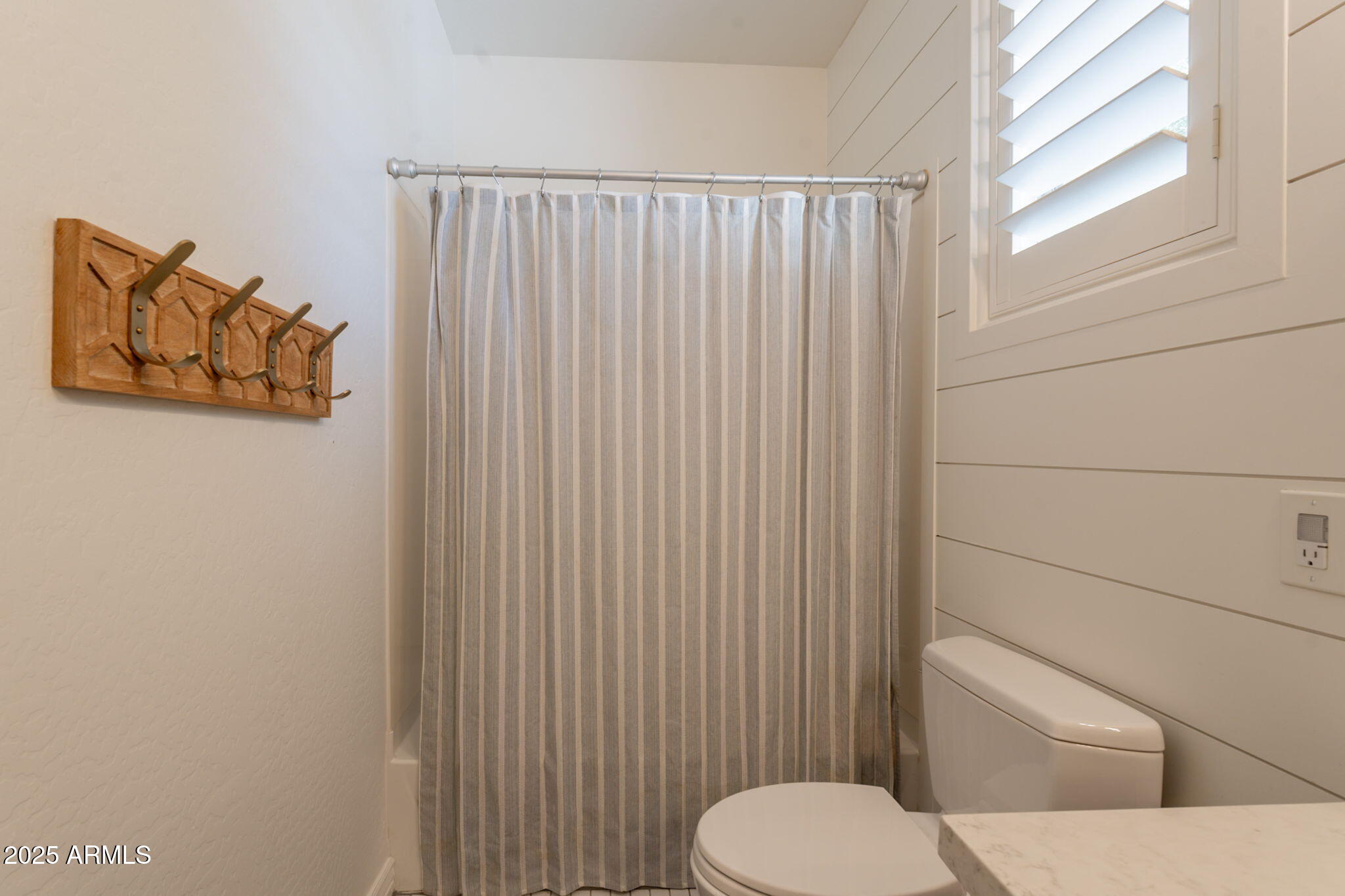 3931 East Weather Vane Road Gilbert, AZ 85296 - Photo 48 of 83 a white toilet sitting next to a shower curtain
