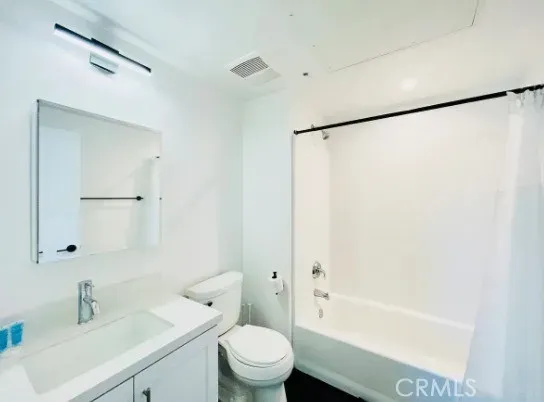 a bathroom with a bathtub shower sink vanity and toilet