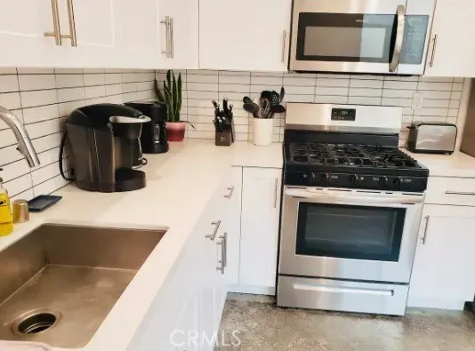 a kitchen with granite countertop a stove and a microwave