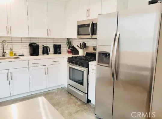 a kitchen with stainless steel appliances white cabinets and a refrigerator