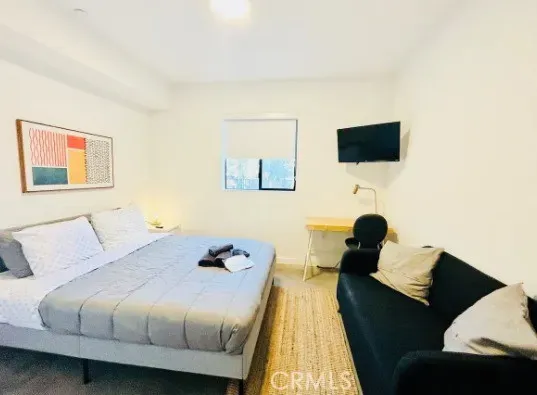 a bed room with a bed and a television