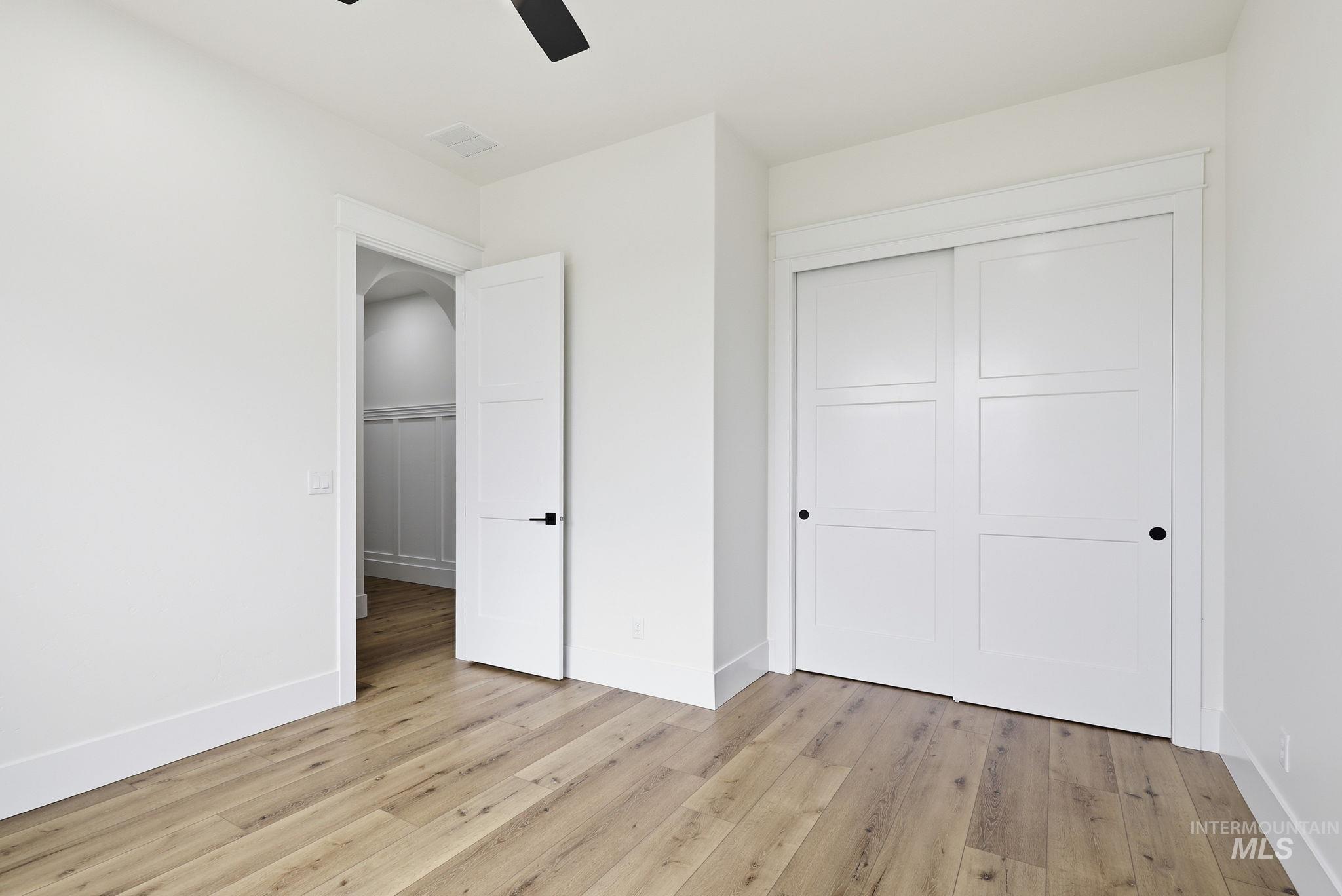 2321 Lower Bluff Road Emmett, ID 83617 - Photo 13 of 31 Custom built-in white shelving system featuring multiple storage tiers, integrated hanging rods, and wood-finish flooring