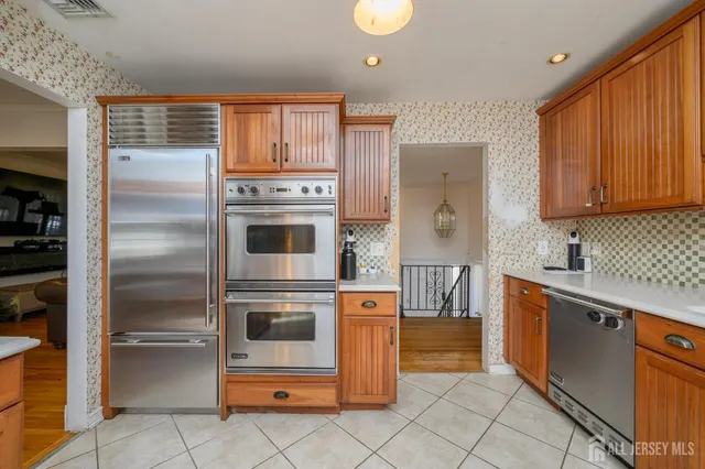 a kitchen with stainless steel appliances granite countertop a refrigerator and a stove top oven