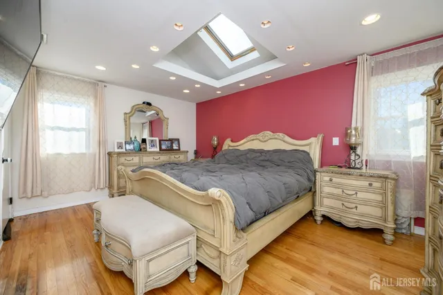 a spacious bedroom with a bed and a dresser