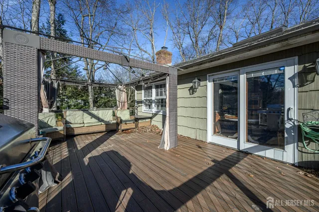 a view of a patio with table and chairs a barbeque with wooden floor and roof