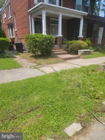a front view of a house with yard and green space