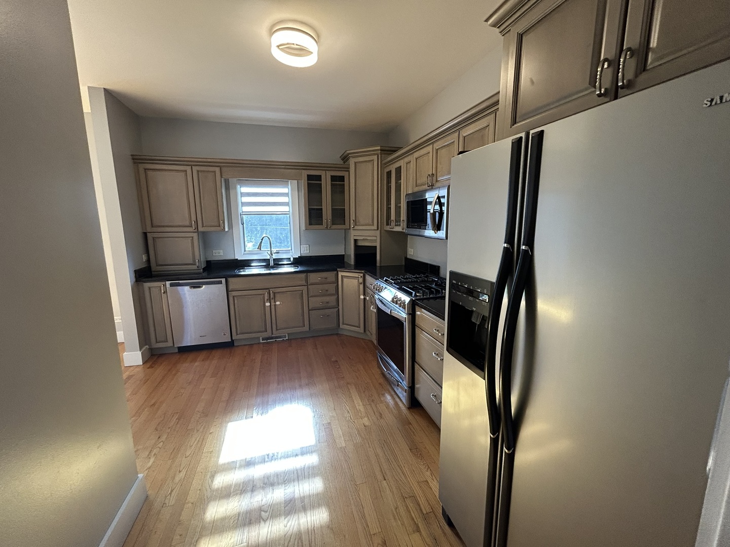 9207 Gerritsen Avenue, Unit 9207 Brookfield, IL 60513 - Photo 15 of 24 a kitchen with stainless steel appliances granite countertop a refrigerator a sink dishwasher a stove and white countertops with wooden floor