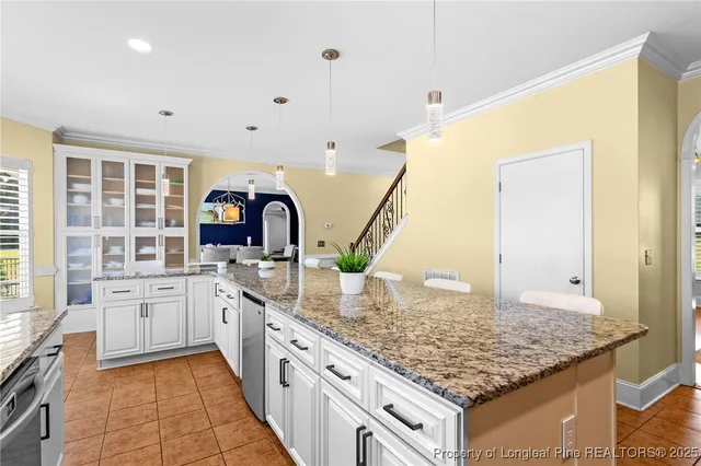 a large kitchen with kitchen island granite countertop a sink and cabinets