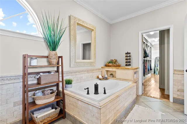 a white bath tub sitting in a bathroom next to a window