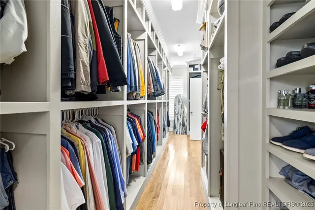 a view of walk in closet with clothes and shoes
