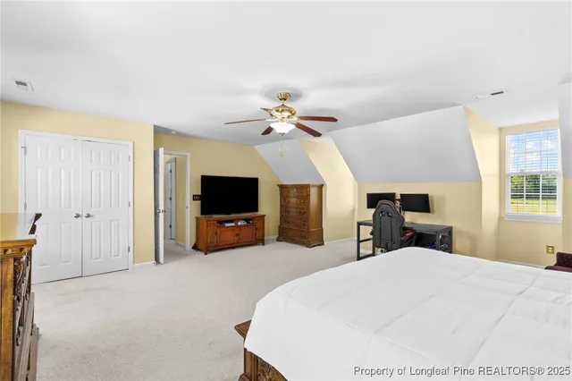 a bed room with a bed a television and a large window
