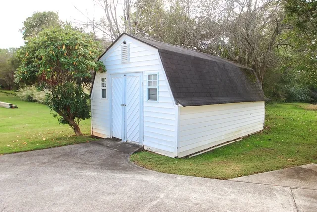 a view of an house with backyard and trees