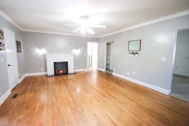 a view of empty room with wooden floor and fireplace