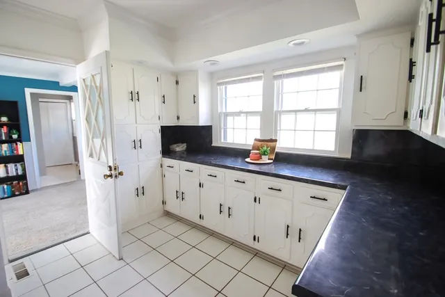 a kitchen with granite countertop a refrigerator and a sink