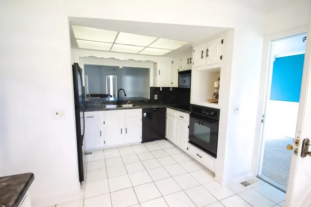 a kitchen with a sink a stove top oven and cabinets