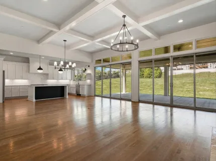 a kitchen with kitchen island granite countertop a sink a counter space appliances and cabinets