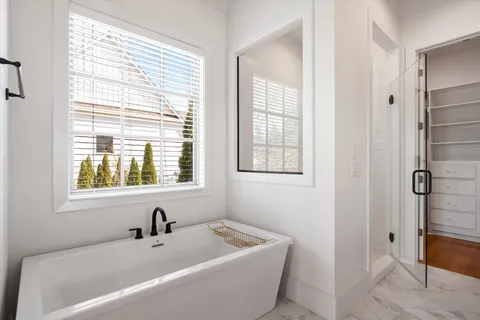 a bathroom with a sink a toilet a mirror a bathtub and shower