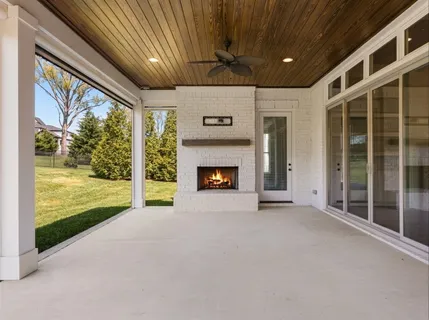 a view of a house with a big yard and large trees
