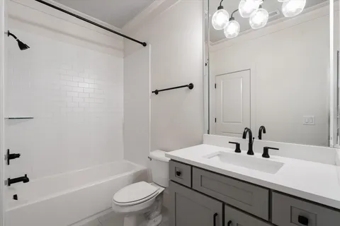 a front view of a house with a garden and trees