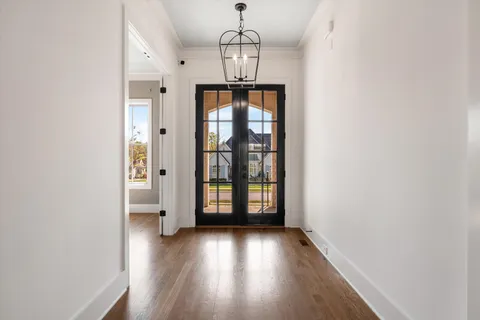 a view of a room with wooden floor and chandelier
