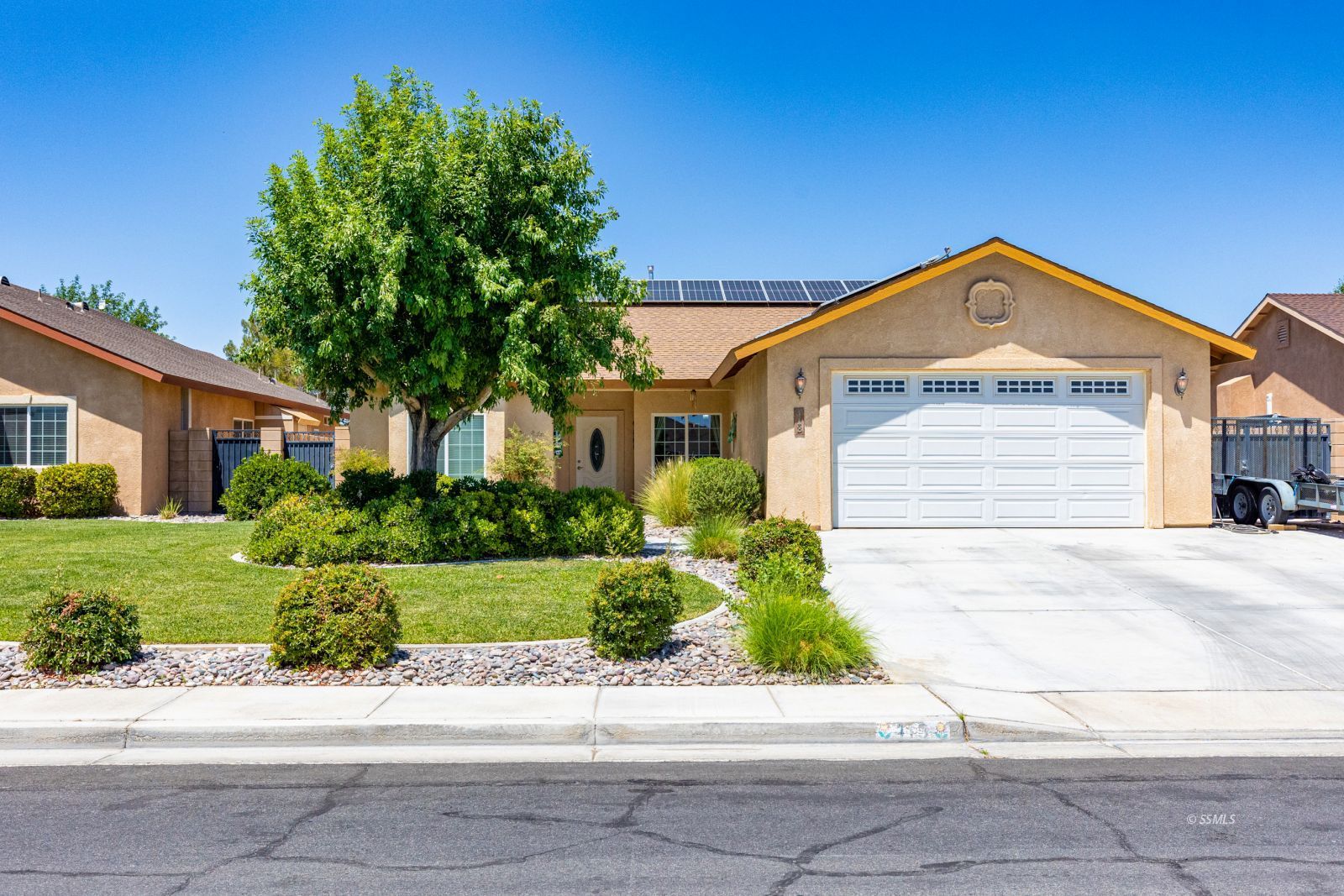 413 Acacia Street Ridgecrest, CA 93555 - Photo 1 of 34 a front view of a house with a yard and garage
