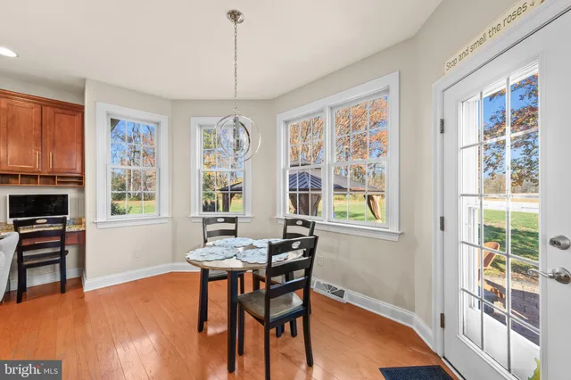 a dining room with furniture a chandelier and wooden floor