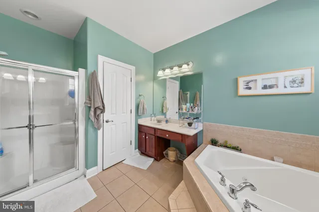 a bathroom with a tub sink and mirror