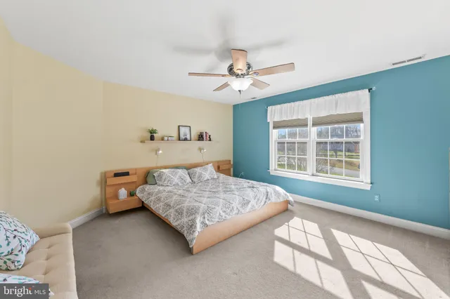 a bedroom with a bed chandelier and a window