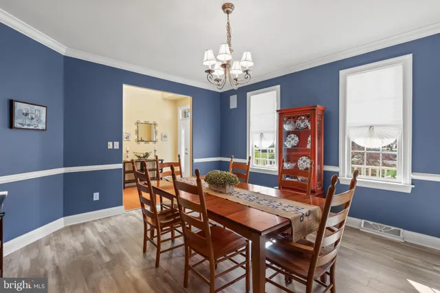 a dining room with furniture a chandelier and window