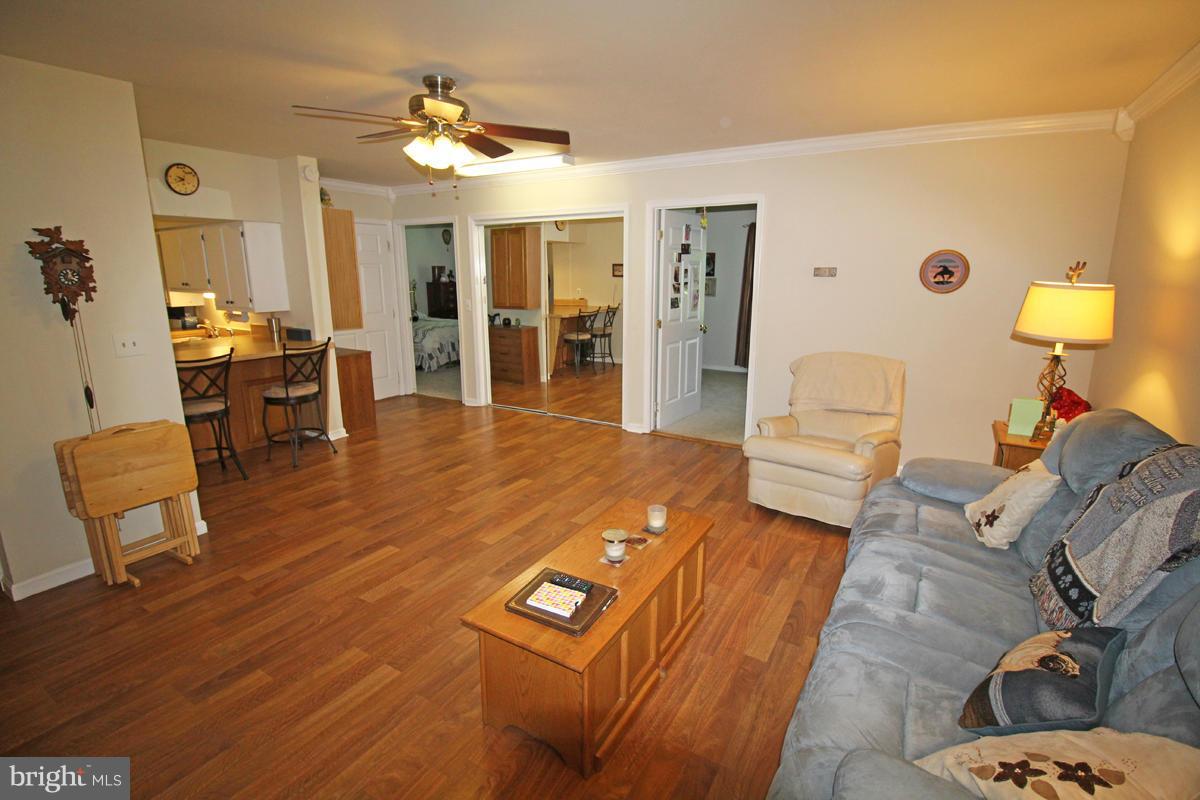 11920 Liberty Road, Unit 106B Frederick, MD 21701 - Photo 4 of 15 a living room with furniture and a dining table with wooden floor