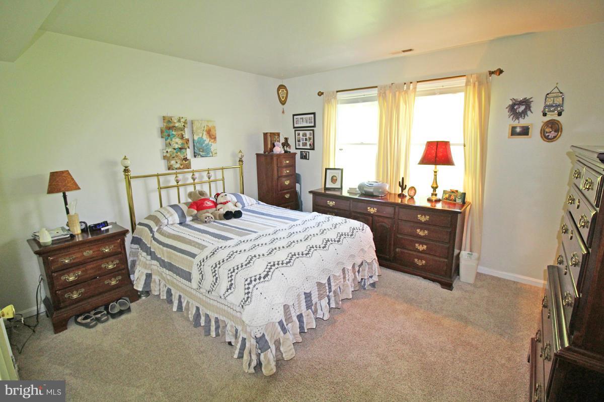 11920 Liberty Road, Unit 106B Frederick, MD 21701 - Photo 10 of 15 a bedroom with a bed and wooden floor