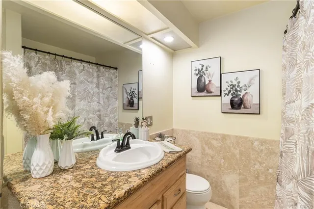 a bathroom with a granite countertop sink a mirror and shower