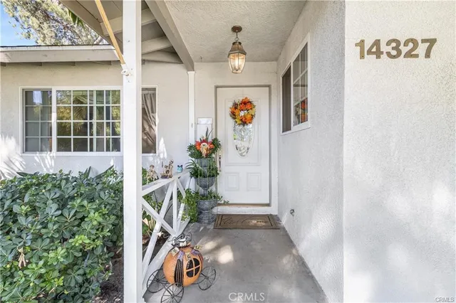 a view of a white house with a yard and potted plants