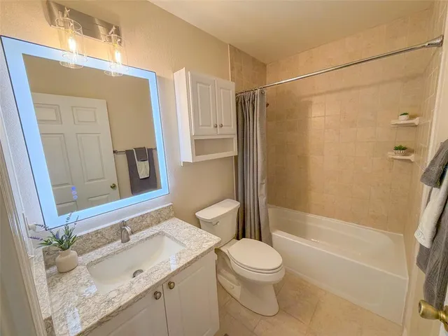 a bathroom with a sink a toilet a mirror and shower