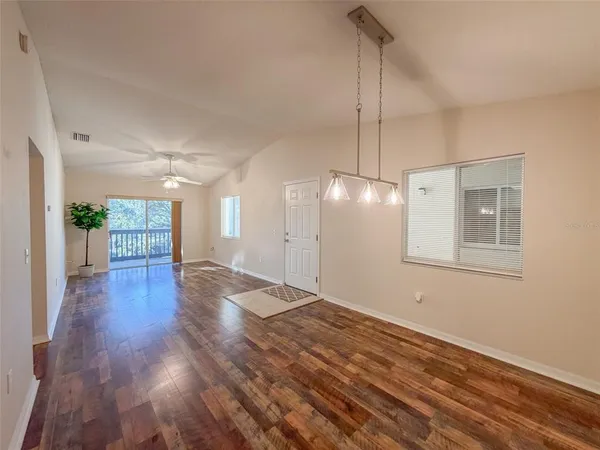 a view of a room with wooden floor and a ceiling fan