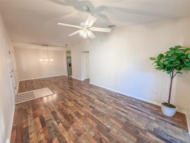 a view of an empty room and kitchen