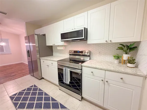 a kitchen with stainless steel appliances granite countertop a sink a stove a microwave and cabinets