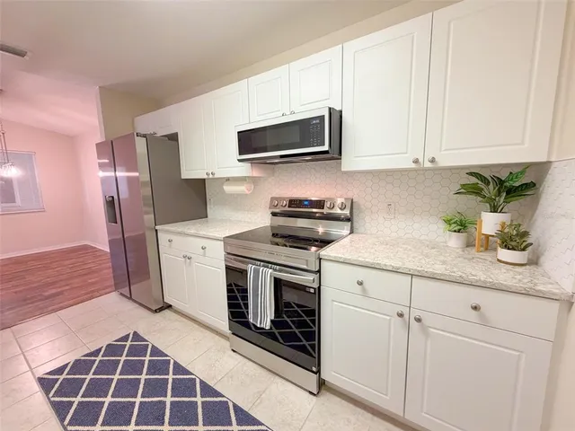 a kitchen with stainless steel appliances granite countertop a sink a stove a microwave and cabinets