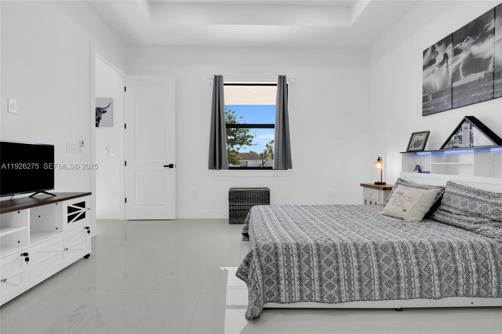 2250 10th Terrace Lehigh Acres, FL 33936 - Photo 12 of 39 a bedroom with a bed and flat screen tv